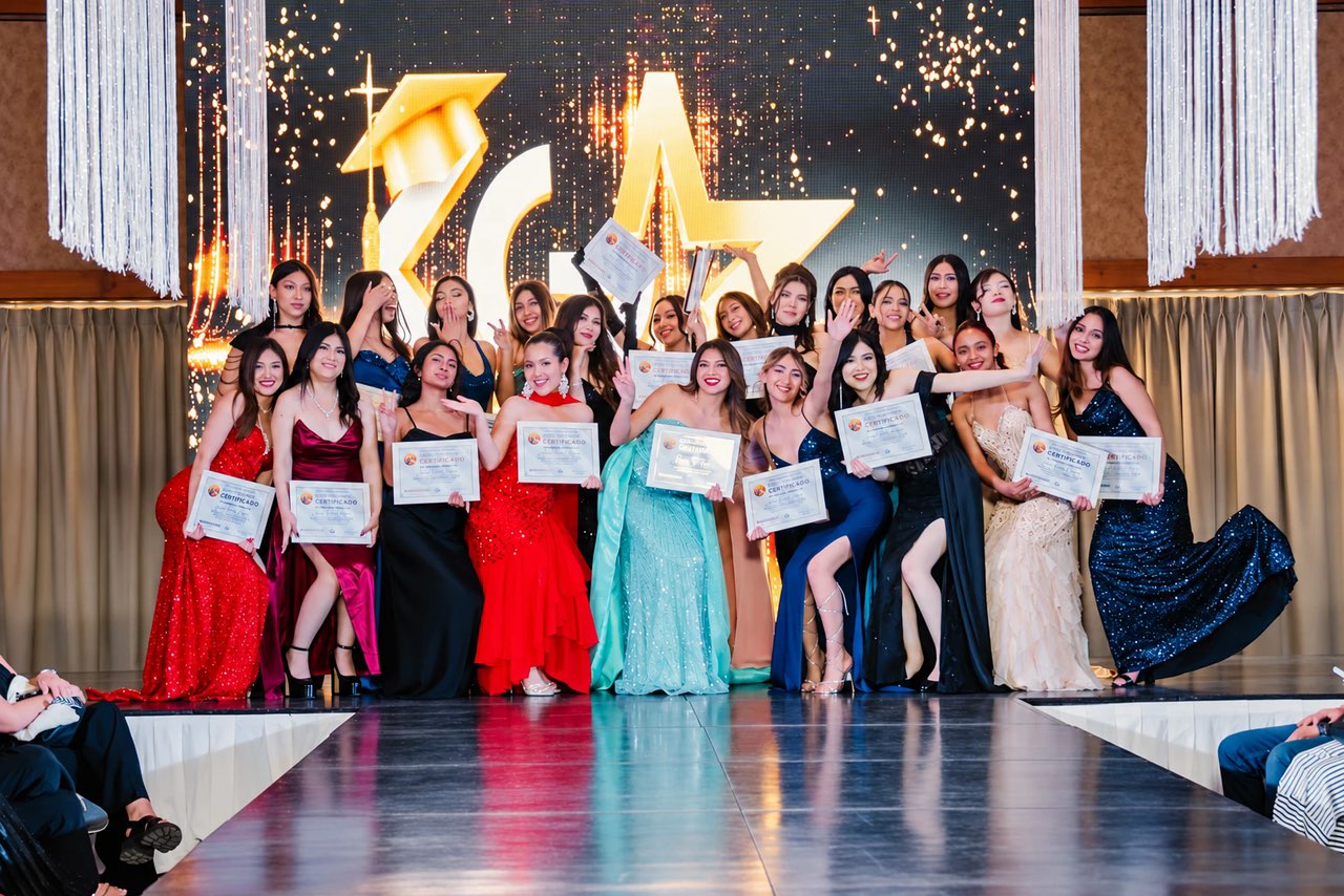 Alumnas de Gallers con vestidos de gala mostrando sus certificados sobre la pasarela