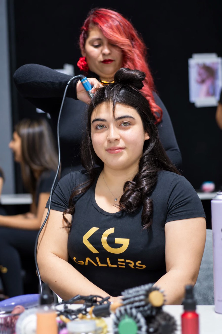 Alumna de Gallers mientras una estilista le hace el peinado antes de un desfile